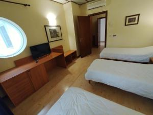 a hotel room with two beds and a television at HOTEL VILLA MABULTON 2.0 in Chiasiéllis