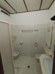 a bathroom with two toilets and a sink and a tub at HOTEL VILLA MABULTON 2.0 in Chiasiéllis