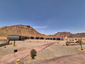 a building in the desert with mountains in the background at Shakria Bedouin Life Camp in Wadi Rum