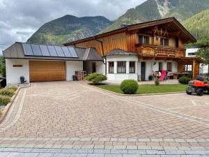 a house with a driveway in front of a mountain at Apart Alpenview in Umhausen