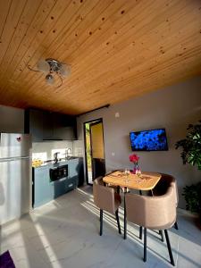 a kitchen with a wooden ceiling and a table and chairs at Villa Paradise in Tsikhisdziri