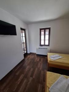 a room with two beds and two windows at Turistički centar Andrićgrad in Višegrad