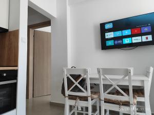 a kitchen with a table with two chairs and a tv at Stefanie Apartment 2 Peraia in Perea