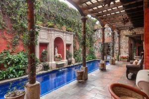 an outdoor patio with a swimming pool with plants at Posada del Angel in Antigua Guatemala