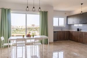a kitchen with a table and chairs and a window at 3 bedroom apartment in Gudja in Gudja