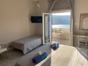 una camera con due letti e vista sull'oceano di Kohili Kolibithra in Tinos a Kollimpithra