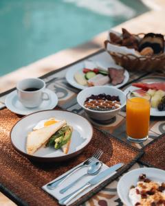 a table with plates of food and cups of coffee at Bratsera Boutique Hotel in Hydra +61 photos