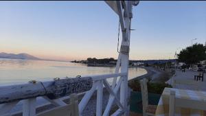 a white fence with birds on it next to a beach at Μαρια in Xylokastro +4 photos