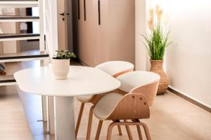 a white table and chairs in a room with plants at Eunoia Luxury Loft in Katerini