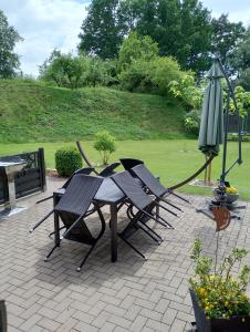 einen Tisch, Stühle und einen Regenschirm auf einer Terrasse in der Unterkunft Landhaus Waldblick in Kritzow