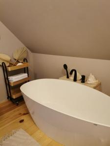 a white bath tub sitting in a room at Klimatyczny dom z bali in Powidz +42 photos