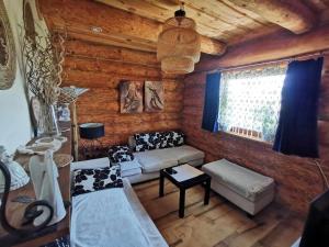 a living room with a couch and a table at Klimatyczny dom z bali in Powidz