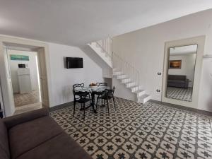 a living room with a table and chairs and stairs at Aquarius Salento in Acquarica del Capo