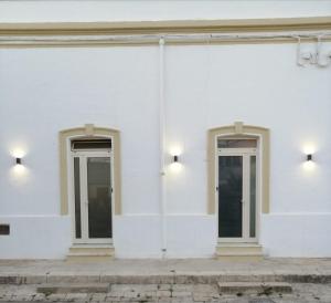 two doors on the side of a white building at Aquarius Salento in Acquarica del Capo
