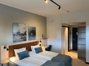 a bedroom with two beds with blue pillows at Pilot Airport Hotel in Vantaa +79 photos