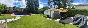a backyard with a small shed and an umbrella at Park side Basement 2 bedroom suite in Kelowna