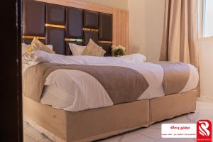 a large bed with a wooden headboard in a bedroom at سيتى للشقق المخدومة in Jeddah