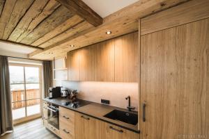 uma cozinha com armários de madeira e um lavatório em Biohof Stöger em Rieden