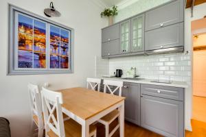 une cuisine avec des armoires blanches et une table en bois dans l'établissement Centrum Bohemia LUX, à Prague