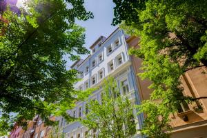 un bâtiment blanc avec des arbres devant dans l'établissement Centrum Bohemia LUX, à Prague