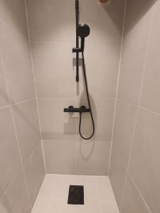 a shower with a shower head in a bathroom at Oslo Stay guesthouse in Oslo