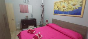 a bedroom with a pink bed with a pink blanket at casa erica in Piombino