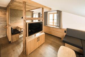 uma sala de estar com uma televisão de ecrã plano e um sofá em Biohof Stöger em Rieden