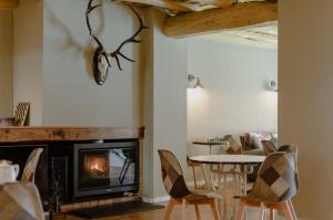 a living room with a fireplace and a table and chairs at La posada de Alájar in Alájar