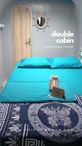a bed with a blue sheet and a sign on it at EL CATAMARAN MAS GRANDE de San Blas, Panama -TODO INCLUIDO- in Isla Wichitupo Grande