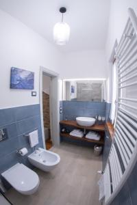 een badkamer met 2 toiletten en een wastafel bij SIDORO - Casa Vacanze Torre del Colle in Bevagna
