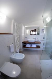 een witte badkamer met een toilet en een wastafel bij SIDORO - Casa Vacanze Torre del Colle in Bevagna