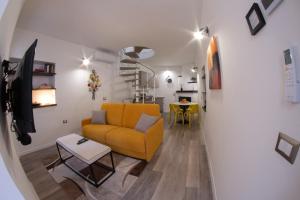 een woonkamer met een gele bank en een tafel bij SIDORO - Casa Vacanze Torre del Colle in Bevagna
