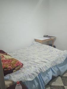 un letto non rifatto in una stanza con tavolo di Cozy Charm Studio in City Center a Martil
