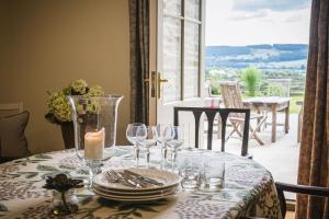 a table with wine glasses and a candle on it at Hollins Farmhouse in Leyburn