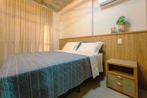 a bedroom with a bed and a night stand at Apartamento Luxo Central - CA704 in Maringá