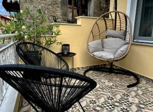 two wicker chairs sitting on a balcony with a pillow at Under the Aqueduct boutique house in Kavála
