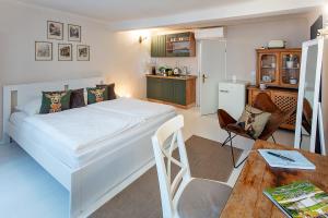 ein Schlafzimmer mit einem weißen Bett und einem Tisch in der Unterkunft Getreidegassen Appartements in Salzburg