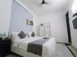 1 dormitorio con 1 cama blanca grande en una habitación en Hotel Hauz Khas Fort View en Nueva Delhi