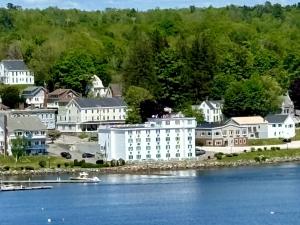 un grand bâtiment blanc sur la rive d'une masse d'eau dans l'établissement Fort Knox Inn, à Bucksport