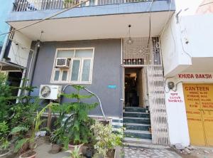 una casa gris con escaleras y plantas delante en Hotel Hauz Khas Fort View en Nueva Delhi
