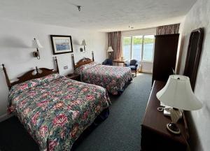 une chambre d'hôtel avec deux lits et une lampe dans l'établissement Fort Knox Inn, à Bucksport
