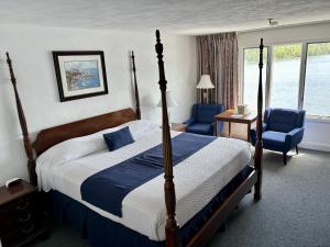 - une chambre avec un lit et deux chaises bleues dans l'établissement Fort Knox Inn, à Bucksport