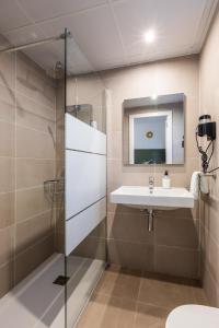 a bathroom with a sink and a mirror at Hostal Alicante in San Antonio
