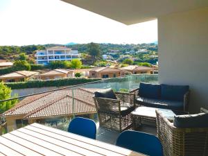 un balcone con tavolo e sedie e vista di Magnifique T2 neuf à 100 m de la plage d'agosta a Albitreccia