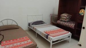 ein kleines Zimmer mit 2 Betten und einem Sofa in der Unterkunft Homestay Legacy Yumai Kuala Rompin in Kuala Rompin