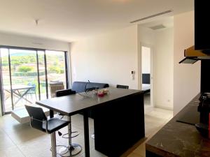 una cucina e un soggiorno con tavolo e sedie di Magnifique T2 neuf à 100 m de la plage d'agosta a Albitreccia Altre 3 foto