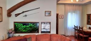 a living room with a couch and a fish tank on the wall at Casa Primetta in Camaiore