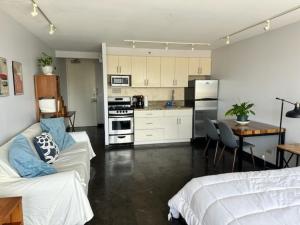 a living room with a couch and a kitchen at Marine Surf Waikiki in Honolulu