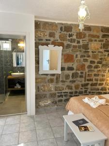 Cette chambre comprend un lit et un miroir sur un mur en briques. dans l'établissement Naiades Almiros Hotel, à Agios Nikolaos
