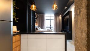 - une cuisine avec des murs noirs, des armoires et des lumières blanches dans l'établissement Vossa Bossa Copan, à São Paulo 291 autres photos
